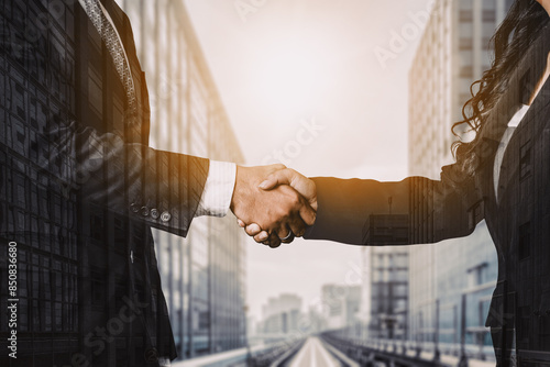 Double exposure image of business people handshake on city office building in background show partnership success of business deal. Concept of corporate teamwork, trust partner and work agreement. uds photo