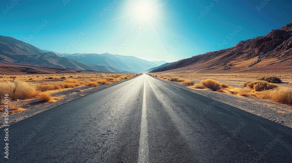 Naklejka premium Empty asphalt road, winding through vast desert, clear blue sky, wideangle shot, bright sunlight, crisp details