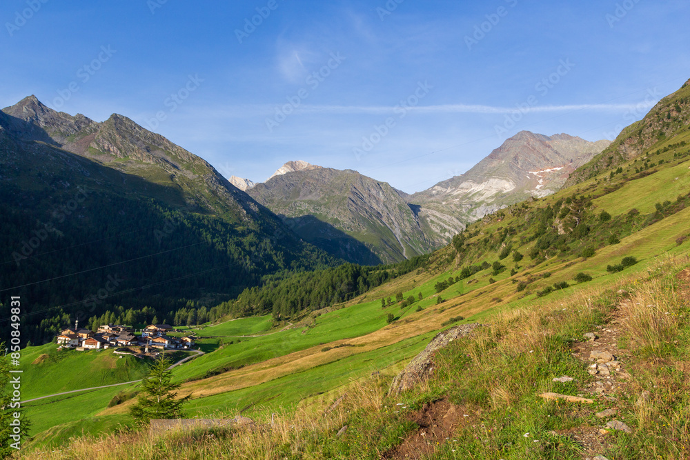 Naklejka premium Rural scene with mountain panorama of summits Hohe Weisse and Hochwilde and houses in village Pfelders near Texel group, South Tyrol, Italy