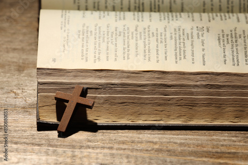 Bible and cross on wooden table, closeup. Religion of Christianity