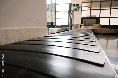 A black conveyor belt with a sign on the wall behind it