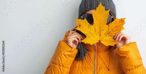 Young Woman Holding Yellow Autumn Leaf In Front Of Face