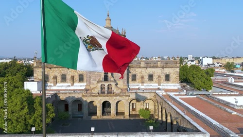 Aerial View of Hospicio Cabañas: Sunlit Museum in Historic Guadalajara with Mexican Flag and Locals Enjoying the Plaza