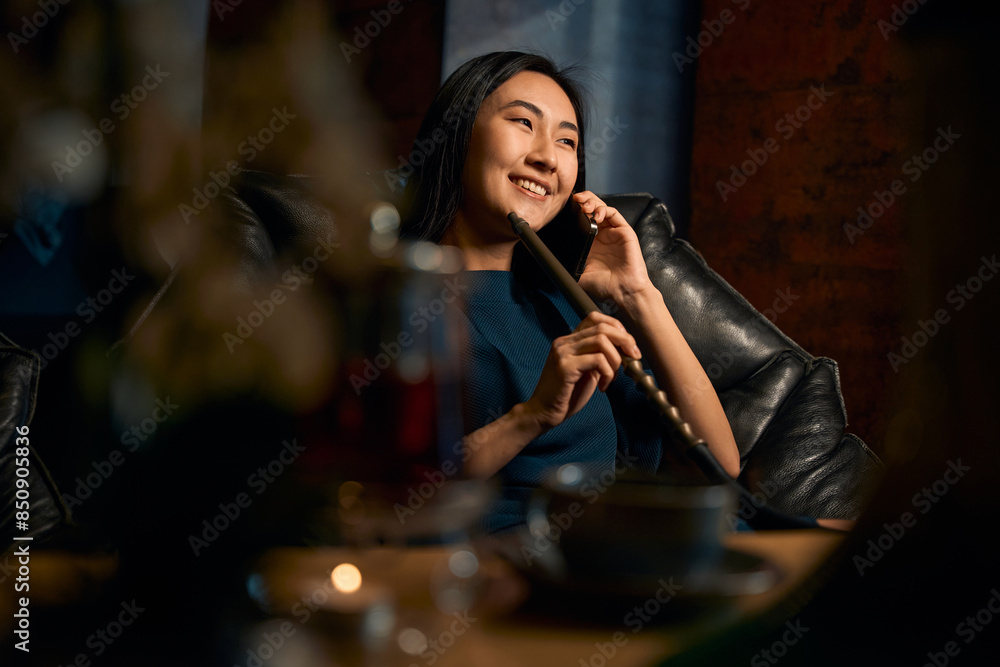 Positive Asian woman talking phone and smiling, enjoying conversation Positive Asian woman talking phone and smiling, enjoying conversation