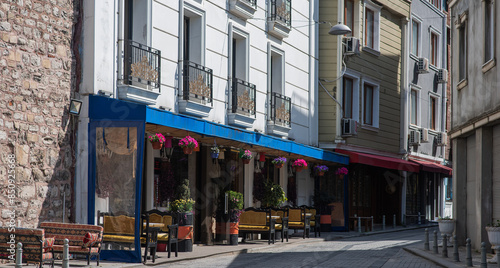 Slika na platnu Urban street with buildings adorned with colorful awnings and hanging flower baskets