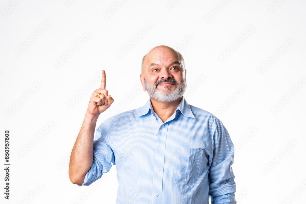 Cheerful Indian asian senior retired old man pointing finger at blank, showing something Cheerful Indian asian senior retired old man pointing finger at blank, showing something