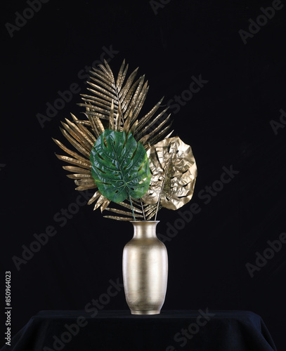 golden palm leaves in a golden vase on a black background
