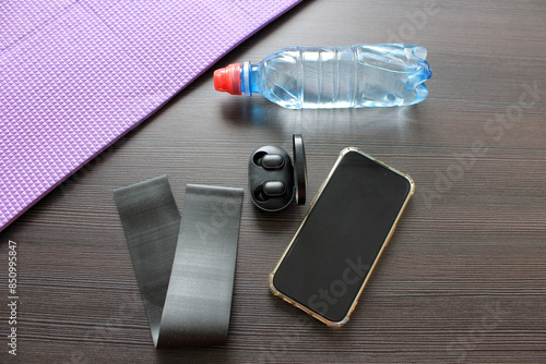 accessories for sports: mat, elastic band, water, phone, headphones photo