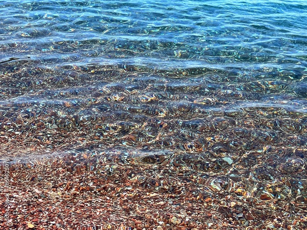 Transparent sea water on pebble beach. Transparent sea water on pebble beach.