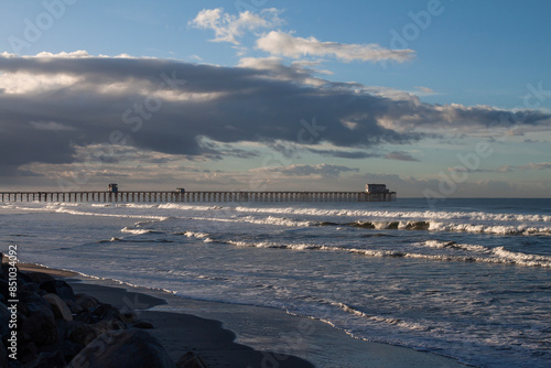 Waves breaking with a pier in the background