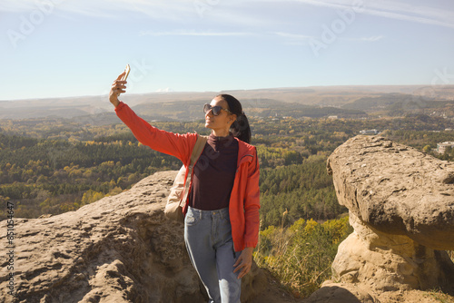 Obraz na płótnie Young beautiful woman traveler taking selfie portrait on mountain top - Happy smiling girl using smartphone - Hiking and climbing rock w salonie
