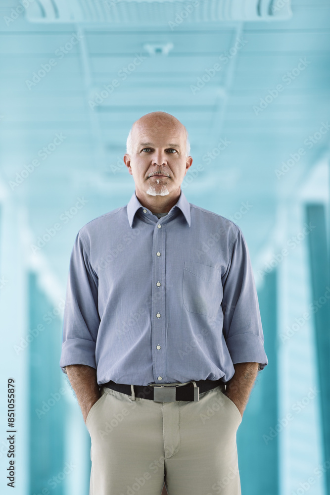 Confident man with goatee, standing, blue background Confident man with goatee, standing, blue background