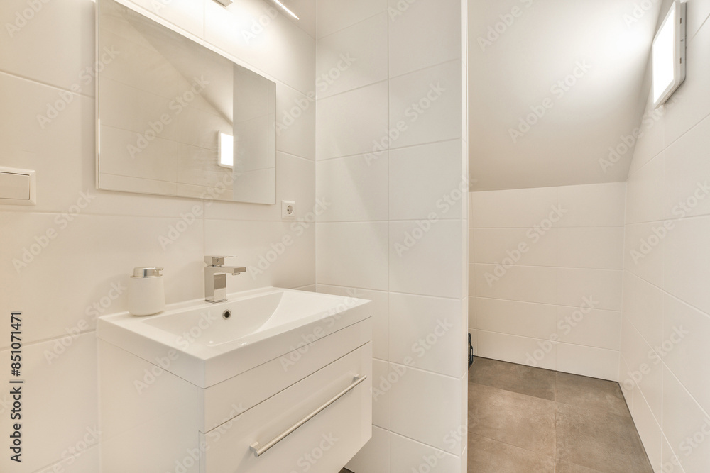 A white bathroom with a sink and a mirror A white bathroom with a sink and a mirror
