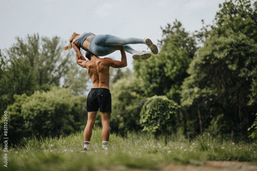 Man lifting and carrying his girlfriend on shoulders in the park, enjoying a workout session together capturing fun and love in nature. Man lifting and carrying his girlfriend on shoulders in the park, enjoying a workout session together capturing fun and love in nature.