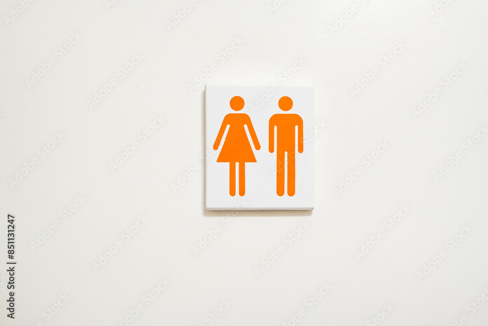 Orange Male and Female Restroom Sign on White Wall Orange Male and Female Restroom Sign on White Wall