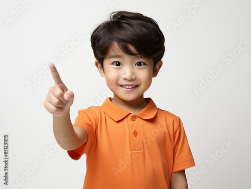 Portrait of an Asian kid wearing an orange outfit on an isolated background with copy space
