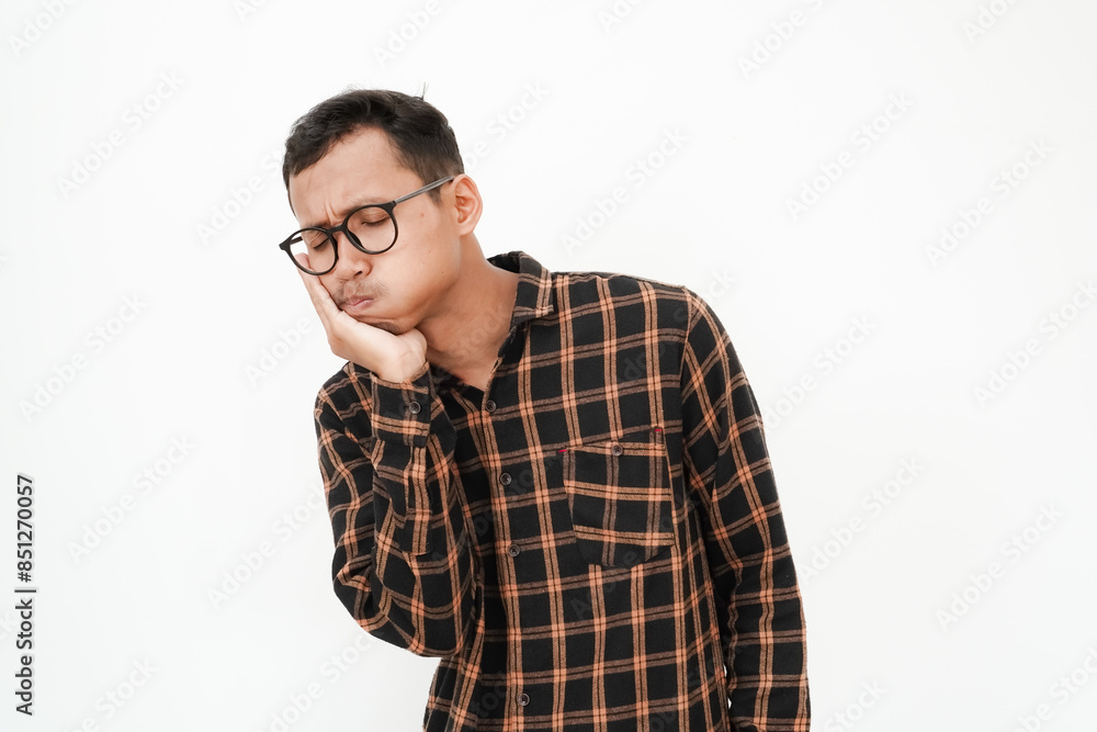 a young man wearing a flannel shirt, wearing glasses having a toothache (holding his cheek with his hand) on a plain white background a young man wearing a flannel shirt, wearing glasses having a toothache (holding his cheek with his hand) on a plain white background
