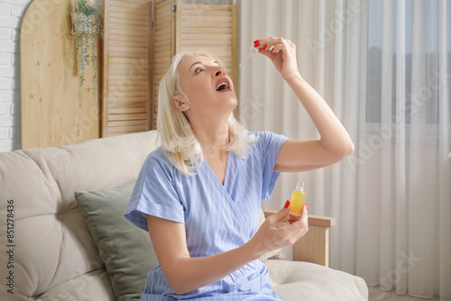 Mature woman taking CBD oil...