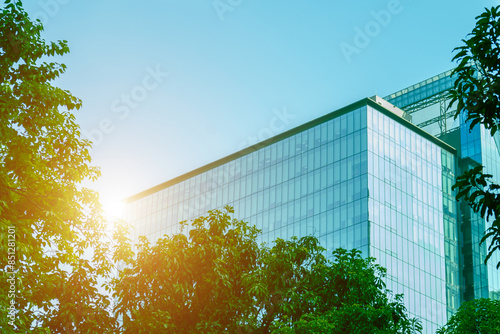 Environmentally friendly office building a sustainable glass building with trees reduces heat and carbon dioxide. Office buildings with a green environment save energy and allow employees to relax.