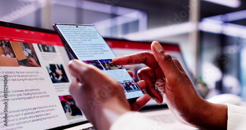 African American Woman Reading Online News on Smartphone and Laptop: Keeping Up photo