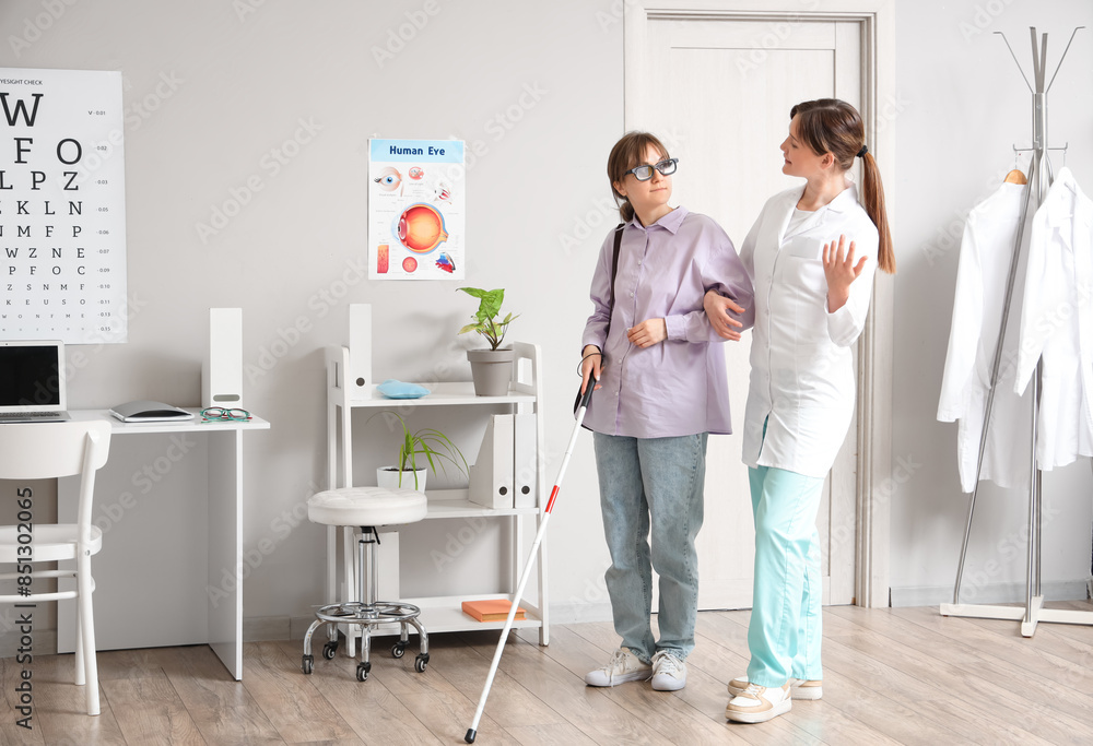 Female ophthalmologist with blind woman walking in clinic Female ophthalmologist with blind woman walking in clinic