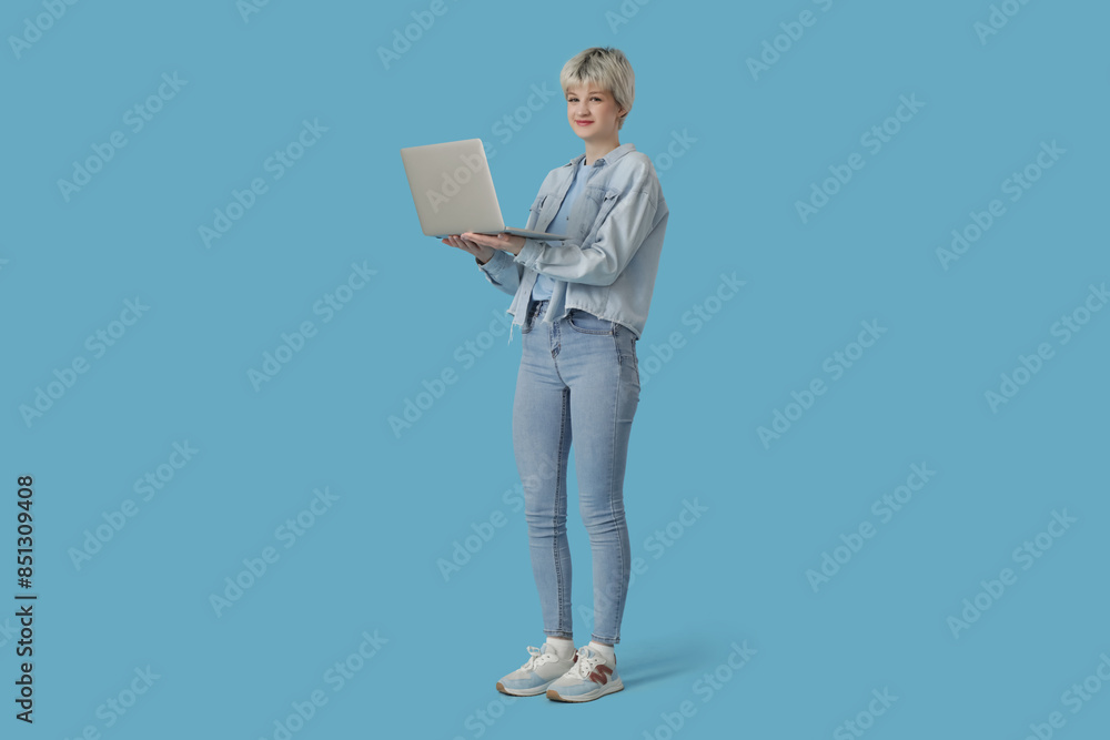 Portrait of beautiful young woman with laptop on blue background Portrait of beautiful young woman with laptop on blue background