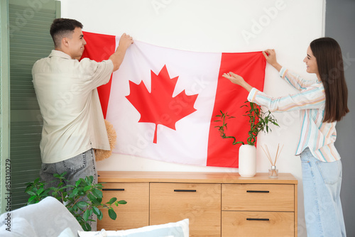 Young couple hanging flag o...