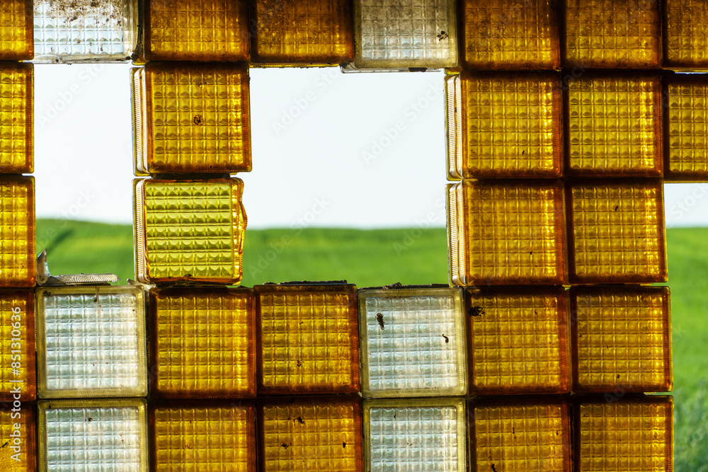Fototapeta premium An old window made of glass blocks. Beautiful decorative orange glass blocks.