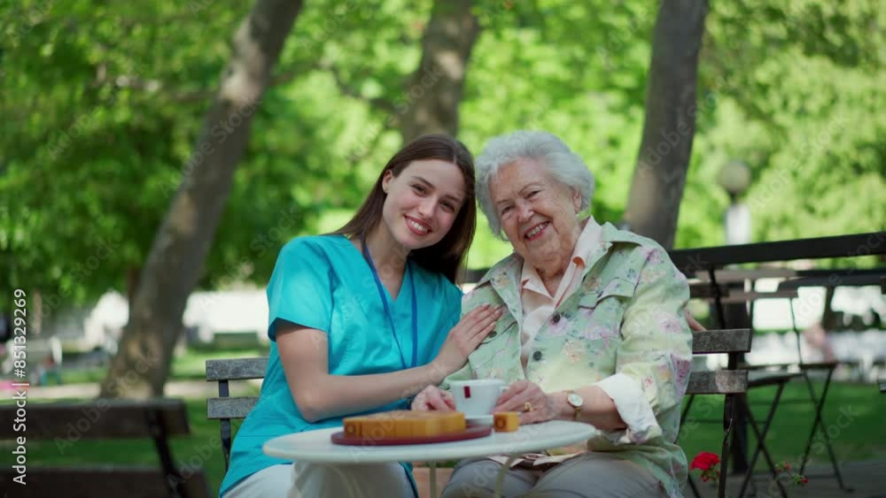 Nurse sitting on coffee with elderly woman in city park. Senior woman enjoying good company and warm weather. Nurse sitting on coffee with elderly woman in city park. Senior woman enjoying good company and warm weather.
