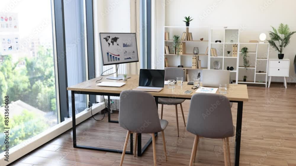 Spacious and bright office conference room with a city view, featuring chairs, a desk, digital screens, and modern decor. Spacious and bright office conference room with a city view, featuring chairs, a desk, digital screens, and modern decor.