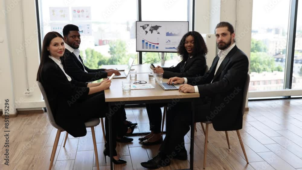 Diverse business team holding a meeting in a modern office, discussing charts and graphs displayed on a screen. Diverse business team holding a meeting in a modern office, discussing charts and graphs displayed on a screen.