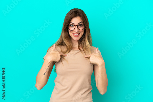 Young caucasian woman isolated on blue background with surprise facial expression