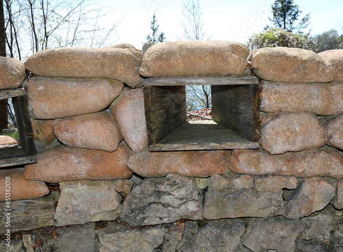 Narrow Trench loophole dug into the ground and reinforced with sandbags photo