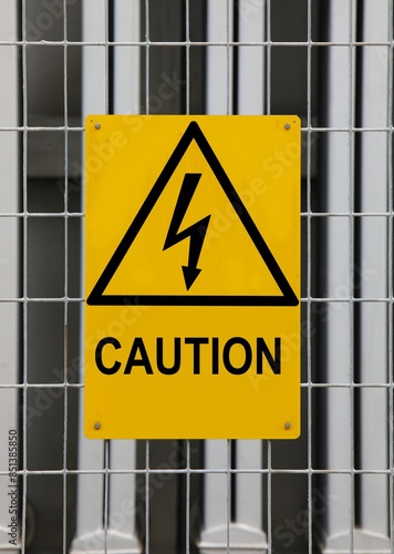 triangular hazard warning sign with lightning bolt on recycling power plant photo