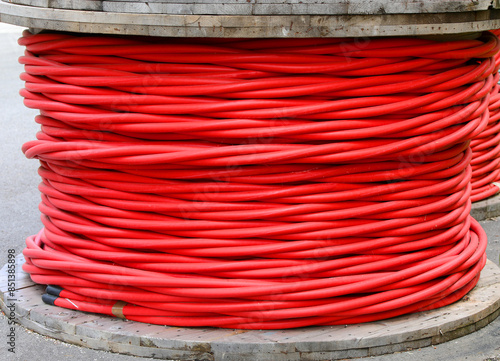 reel of high voltage insulated red electrical cable in power company warehouse photo