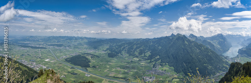 Large panorama of the Linth plain from the Hirzli mountain in summer with blue sky and clouds
