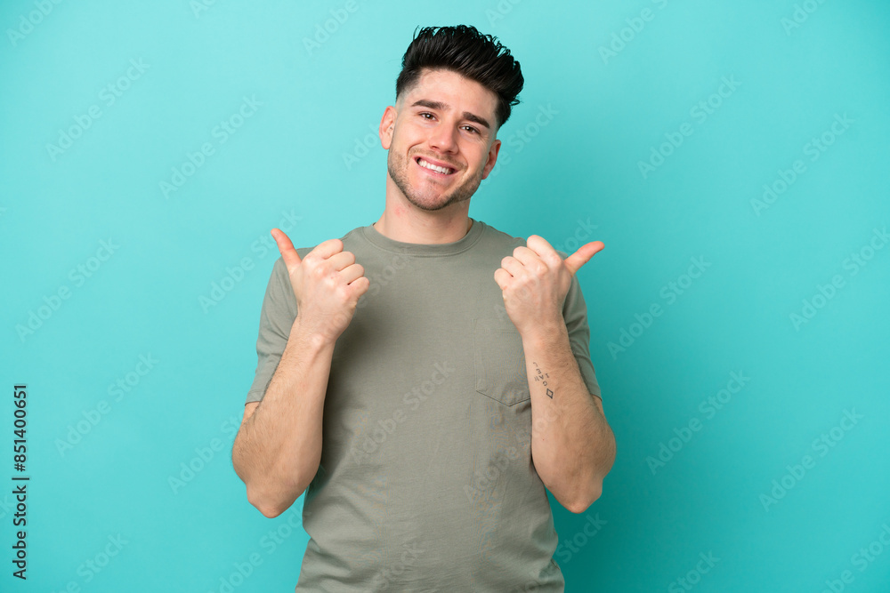 Young caucasian man isolated on blue background with thumbs up gesture and smiling Young caucasian man isolated on blue background with thumbs up gesture and smiling