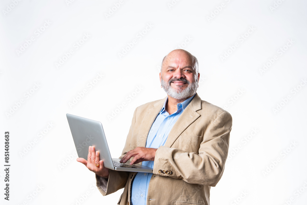 portrait of senior old Indian asian businessman using laptop against white background portrait of senior old Indian asian businessman using laptop against white background
