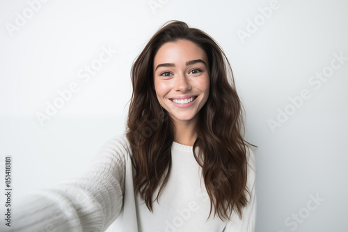 Young pretty brunette girl over isolated white background making a selfie © luismolinero