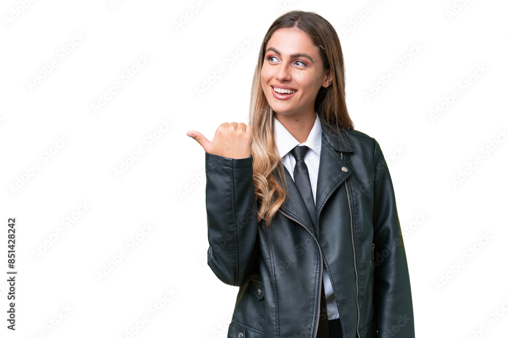 Business pretty Uruguayan woman wearing a biker jacket over isolated background pointing to the side to present a product Business pretty Uruguayan woman wearing a biker jacket over isolated background pointing to the side to present a product