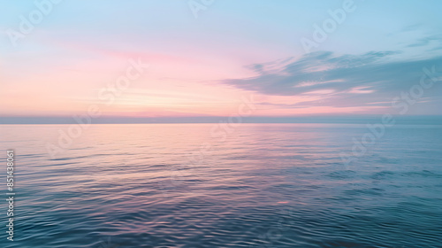 A calm ocean with a soft pastel sunset.