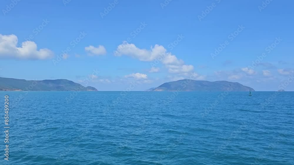POV from a moving boat sailing through the blue sea water. Looking at blue sky clouds and mountain at Con Son island, Vietnam in the morning. POV from a moving boat sailing through the blue sea water. Looking at blue sky clouds and mountain at Con Son island, Vietnam in the morning.