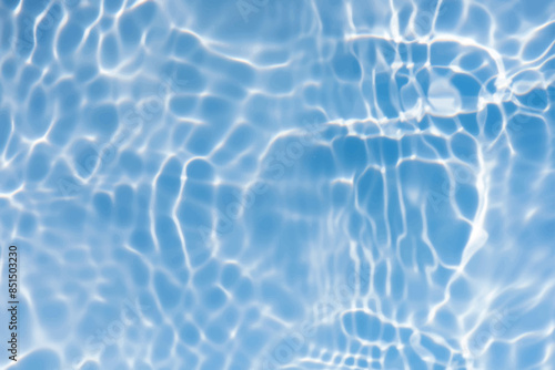 Blue water with ripples on the surface. Defocus blurred transparent blue colored clear calm water surface texture with splashes and bubbles. Water waves with shining pattern texture background.