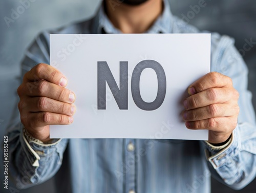 ultrarealistic photograph of a man holding banner with text 'NO'. This piece has been captured shot on a DSLR with a 70mm lens, high key lighting with natural light and white balance. photo