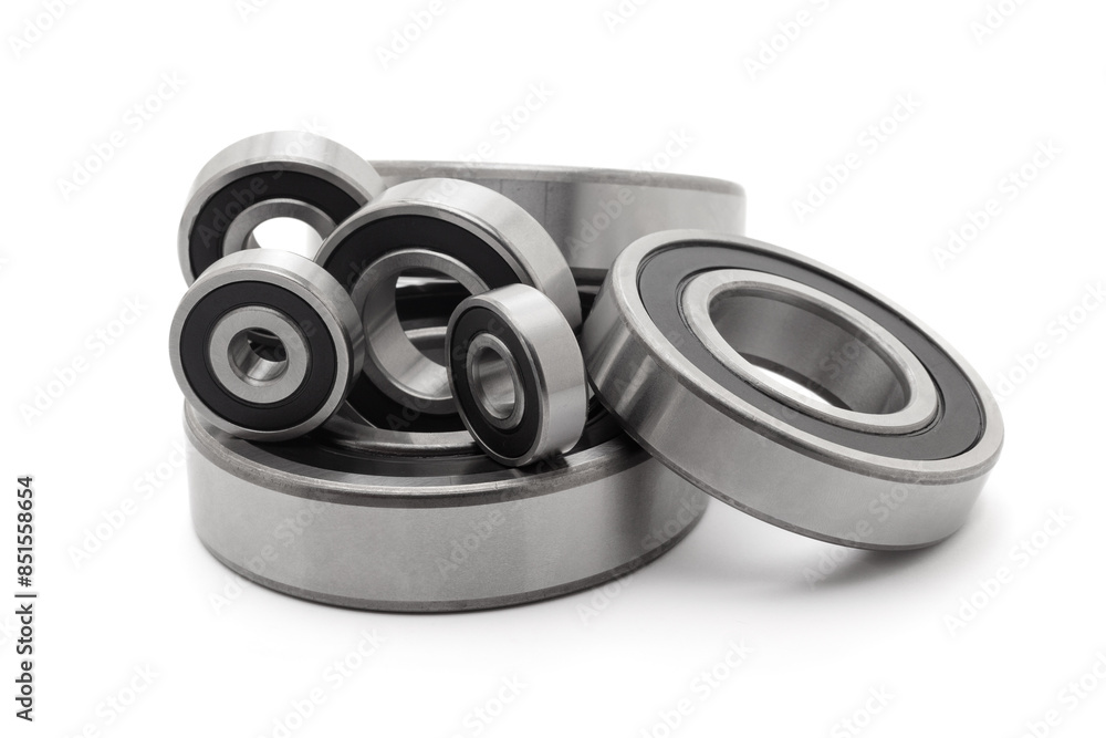A collection of assorted tapered roller bearings of various sizes, isolated on a white background. A collection of assorted tapered roller bearings of various sizes, isolated on a white background.