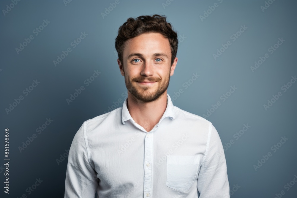 Fototapeta premium Portrait of a glad man in his 30s wearing a simple cotton shirt in plain cyclorama studio wall