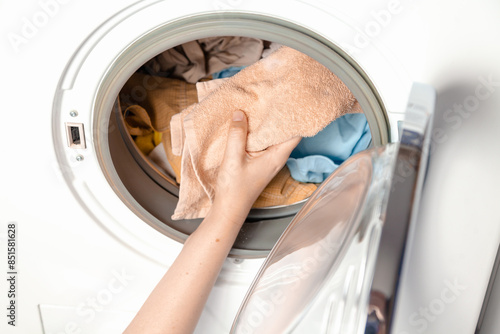 Hands putting laundry in the washing machine....
