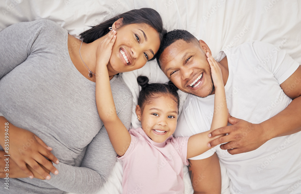 Family, above portrait and girl on bed in morning for bonding, relationship or relax together in bedroom. Top view, young child and man parent with woman for wake up, love or happiness in home Family, above portrait and girl on bed in morning for bonding, relationship or relax together in bedroom. Top view, young child and man parent with woman for wake up, love or happiness in home
