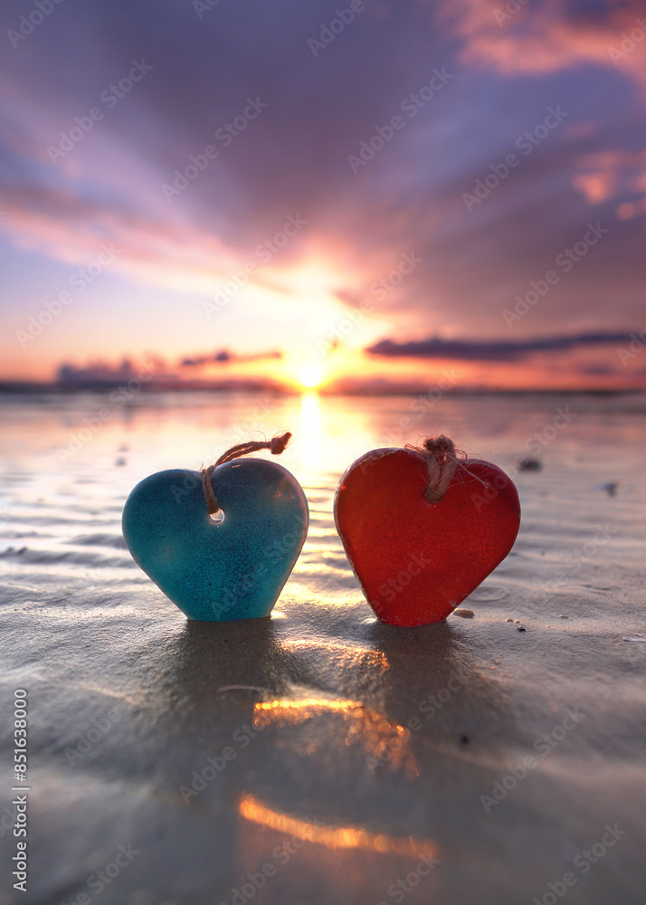 Fototapeta premium two hearts in sunset at the beach on the sea