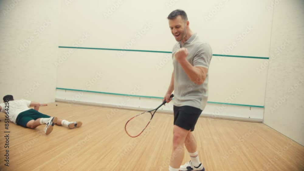 A player falls to the ground on the squash court A player falls to the ground on the squash court